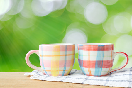 Coffee cup on wood table and green natural background., With copy space.の写真素材
