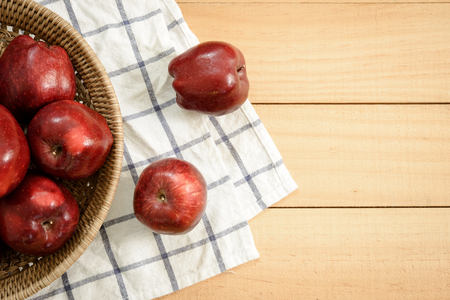 Apples in baske put on a wood background with copy space.の写真素材
