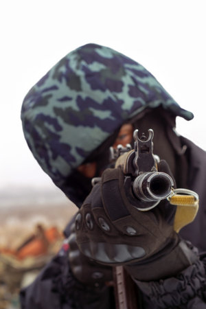 A military man holding a gun and aiming