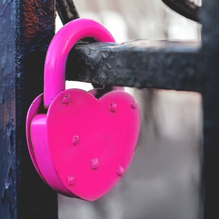 padlock fastened on the railing of the bridge as a symbol of eternal love. old tradition at the wedding. blurred background.の写真素材