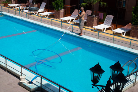 Anapa, Russia - May 1, 2020: swimming pool cleaning. a man is cleaning the pool. service care