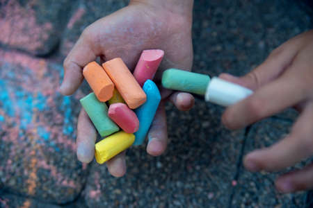 Close-up of colored chalk in the hands of a child. Concept of choice, decision making, dilemma, problems.のeditorial素材