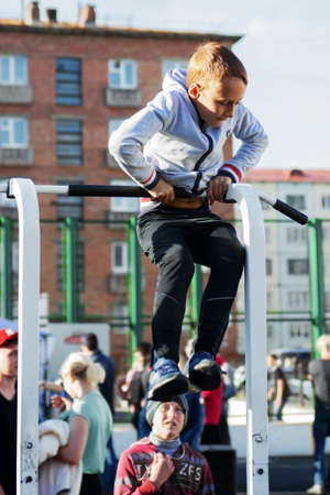 Norilsk, Russia - August, 28, 2016: Little boy doing exercise on the horizontal bar. Street workout. Childrens sport and healthy lifestyle conceptのeditorial素材