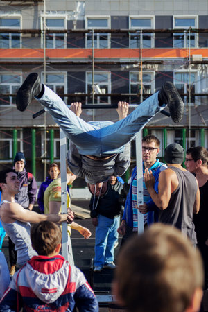 Norilsk, Russia - August, 28, 2016: Back view of handsome shirtless man exercising on horizontal bar...