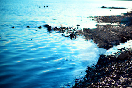 Polluted lake shore. A reservoir polluted by the Norilsk Nickel company. The concept of pollution of reservoirs, environment, ecological disaster. Blurred image, selective focus. No focusの写真素材