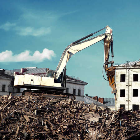 excavator demolishing a brick building. Machinery Demolishing Building.の写真素材
