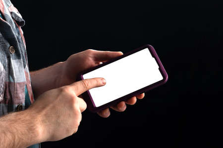 Mobile phone in the hand of a teenager, mocap copy space, hand in the shadeの写真素材