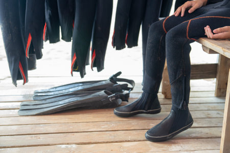 The diver puts on fins. Diver and equipment. Wetsuit fins and diving equipment close-upの写真素材