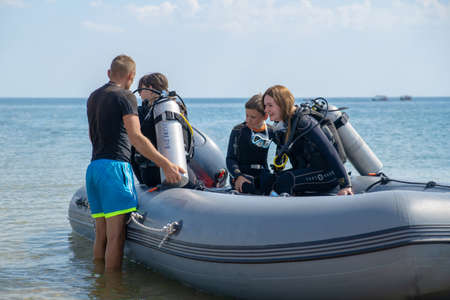 Anapa, Russia - June 20, 2019: A group of tourists divers in a rubber boat sail on the sea.のeditorial素材
