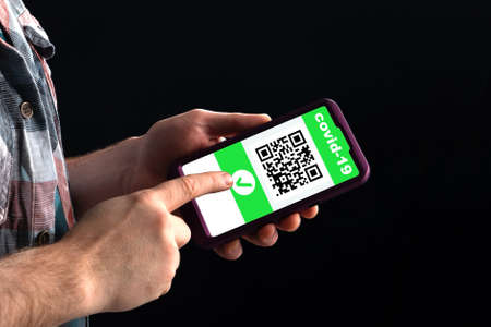 A man shows a qr code in a smartphone containing information about vaccination against coronavirusの写真素材