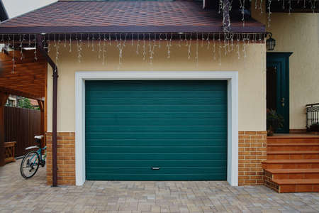 garage door. A garage with blue doors at the end of a drivewayの写真素材