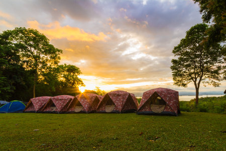 The sun is shining above camping tents in a morning day