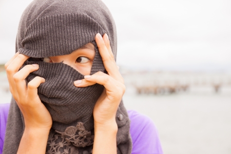 an asian women face with covered ther head is glacing lookの写真素材
