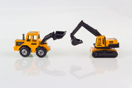 miniature toy excavators isolated on whiteの写真素材