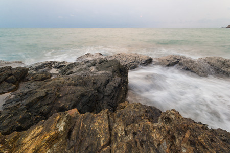 rocks on the beach with waving of sea waterの写真素材