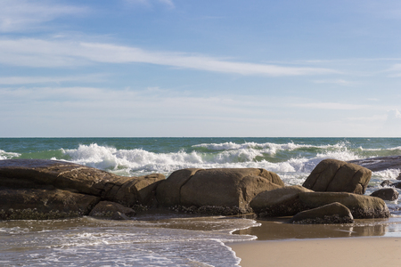 seascape with splash water over the rock under blue skyの写真素材