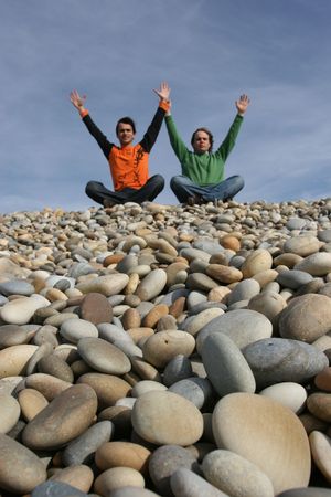 two young men with raised arms at the beach - focus on 1st planの写真素材