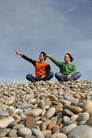 two casual young men gesturing at the beachの写真素材