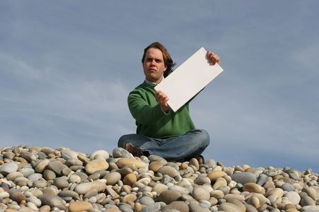 Young Man Holding White Card at the beachの写真素材