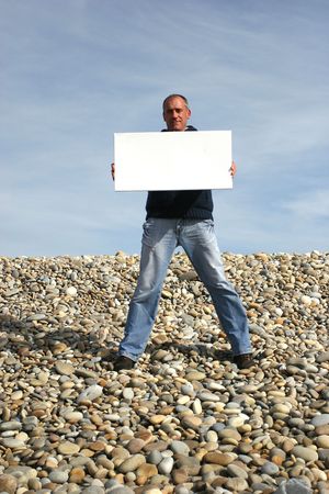 Young Man Holding White Card at the beachの写真素材
