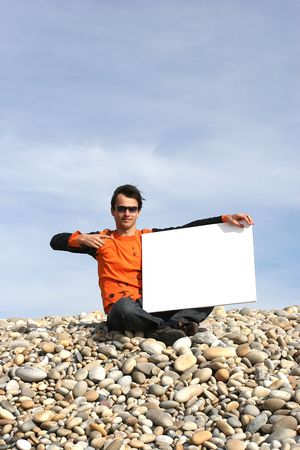 Young Man Holding White Card at the beachの写真素材