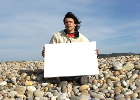 Young Man Holding White Card at the beachの写真素材