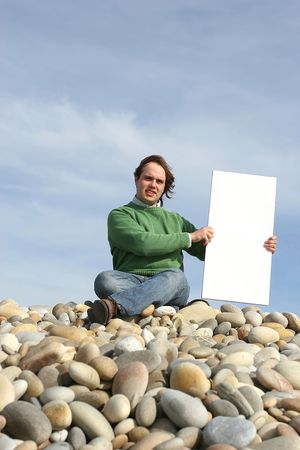 Young Man Holding White Card at the beachの写真素材