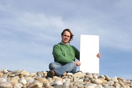 Young Man Holding White Card at the beachの写真素材