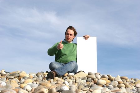 Young Man Holding White Card at the beachの写真素材