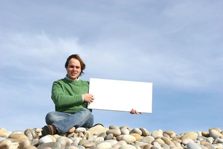 Young Man Holding White Card at the beachの写真素材