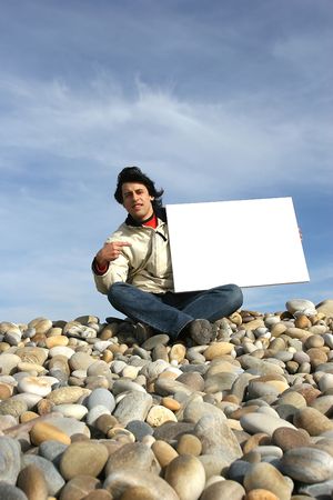 Young Man Holding White Card at the beachの写真素材