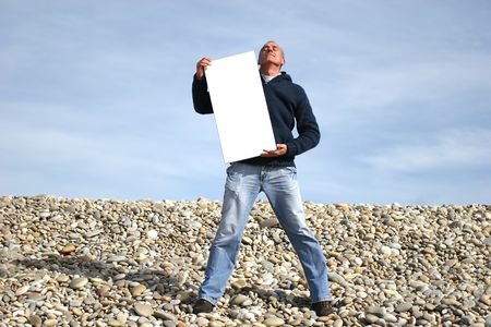 Young Man Holding White Card at the beachの写真素材