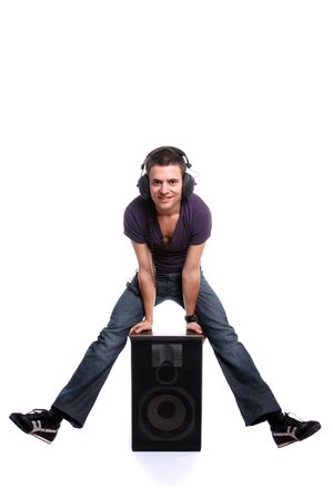 Young man with headphones, seating in a speaker, isolated in white backgroundの写真素材