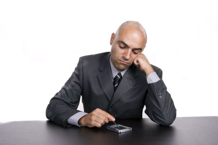 Young bored businessman, working at the desk, isolated in white backgroundの写真素材