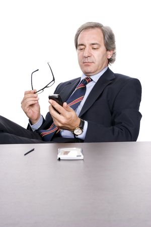 Mature businessman dialing a number in cellphone, over white backgroundの写真素材
