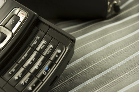 Detail of a cellphone over a tie