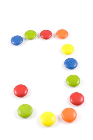 Letter J made of colored smarties, isolated over whiteの写真素材