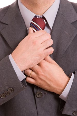 Business man fixing his tie, isolated over whiteの写真素材