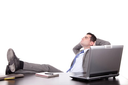 Successful businessman relaxing over desk, isolated in white backgroundの写真素材