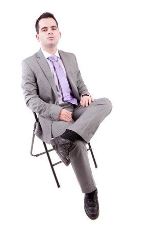 Young business man sitting on a chair, isolated over whiteの写真素材