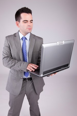 Young business man working with laptop, isolatedの写真素材