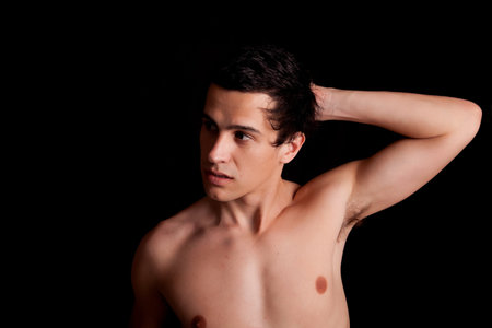 Young boy posing isolated over black backgroundの写真素材