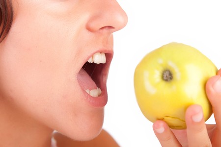 Woman eating green apple - isolated over whiteの写真素材