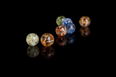 Colored marbles isolated over black backgroundの写真素材