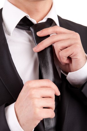 Business man fixing his tie, isolated over whiteの写真素材