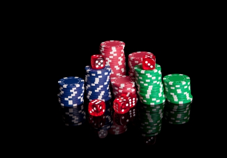 Poker chips and dices, isolated over black backgroundの写真素材