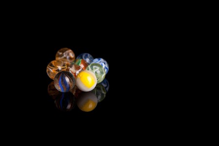 Colored marbles isolated over black backgroundの写真素材