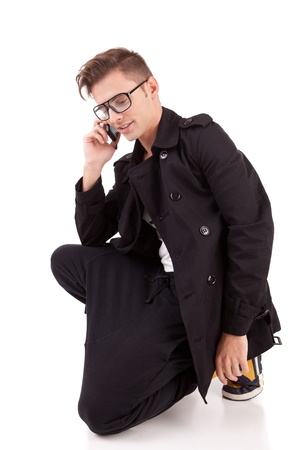 Young man at the phone, isolated over whiteの写真素材