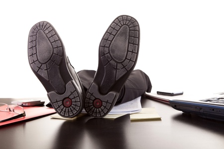 Successful businessman relaxing over desk, isolated in white backgroundの写真素材