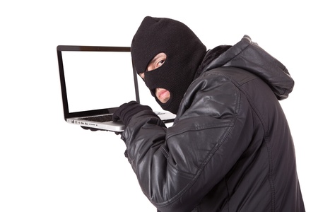 Disguised computer hacker with laptopの写真素材
